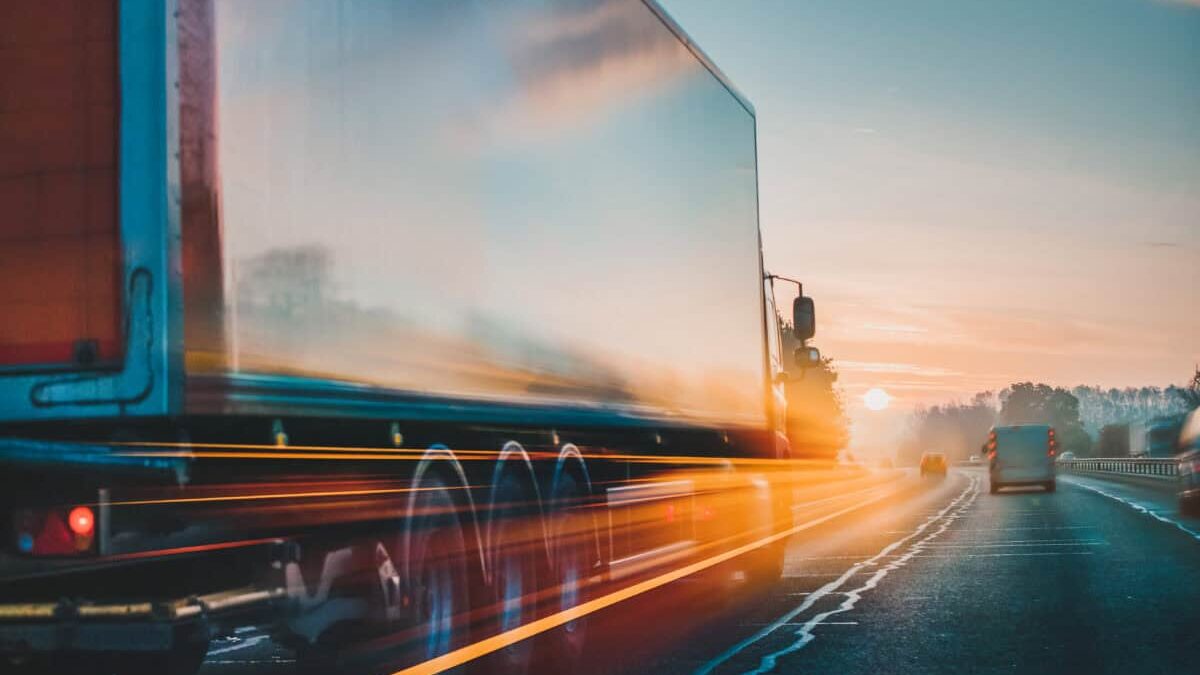 delivery truck drives into sunset