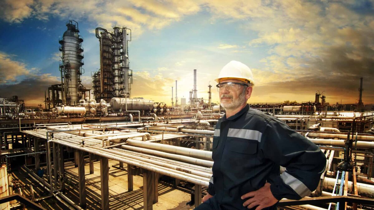 A worker overlooks an oil refinery plant.